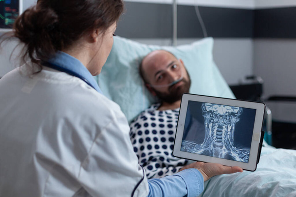 Ιατρός παρουσιάζει επιλογές για τον ασθενή για τη θεραπεία της πάθησης του λαιμού, ενώ κοιτάζοντας μαγνητική τομογραφία - Φωτογραφία, εικόνα