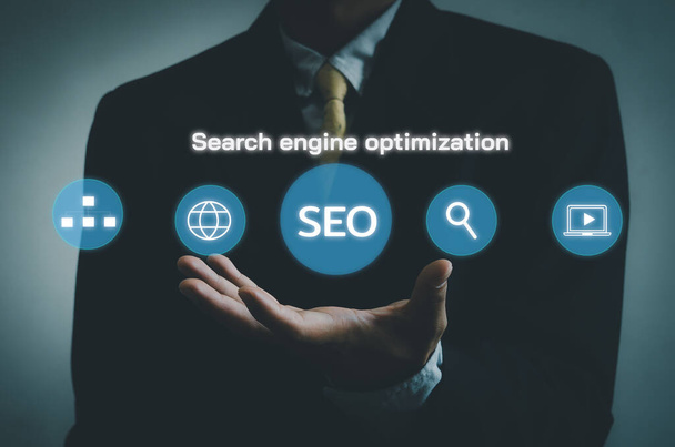 Hand businessman icon SEO Search engine optimization  virtual screen.Social network digital business concept. - Фото, изображение