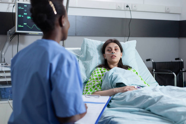 Professionele verpleegkundige lezen patiëntenkaart op klembord verstrekken van medische zorg aan patiënten met een laag spo2 - Foto, afbeelding