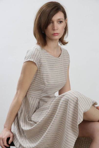 Çizgili pamuklu yaz elbisesi giymiş bir kadının stüdyo fotoğrafı.. - Fotoğraf, Görsel