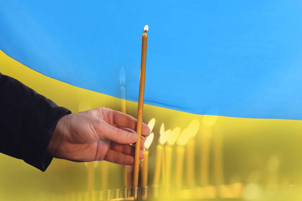Man with candle against Ukrainian national flag, closeup - Valokuva, kuva