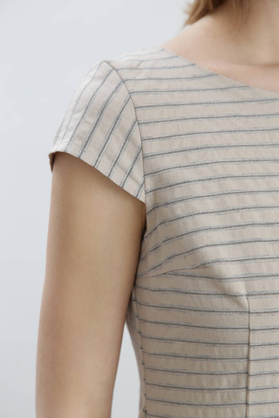 Крупним планом зображення жінки в лляній смугастій літній блузці. Деталь блузки в області плечей
. - Фото, зображення