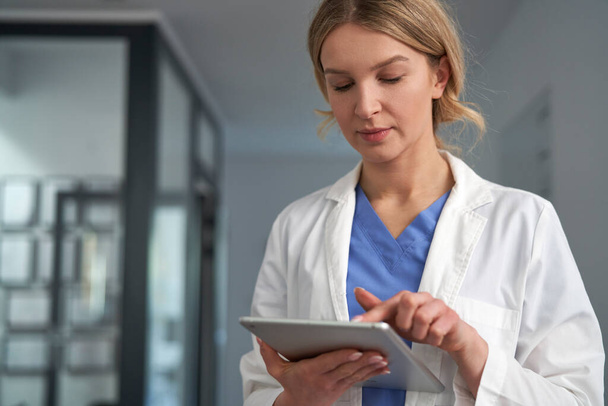 Caucasian female doctor using digital tablet in medical clinic  - Фото, изображение