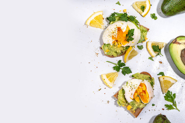 Healthy diet sandwiches for breakfast, snack. Toast with guacamole avocado salsa and poached egg  - Фото, изображение