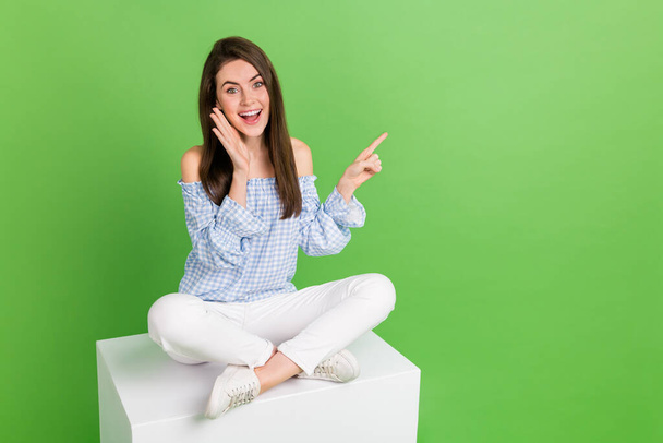 Portrait of sweet adorable female point finger empty space promote product offer isolated on green color background - Valokuva, kuva