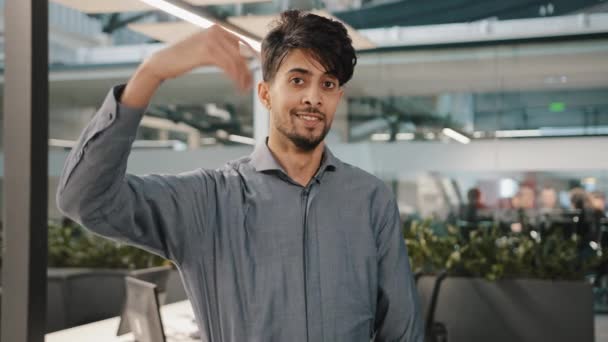 Jovem sorrindo árabe gerente de escritório estudante empregador olhando para câmera convidar gesto mão pedindo cumprimentar usando símbolo de boas-vindas fazendo escolha masculina onda mão falando linguagem corporal hey você vem aqui - Filmagem, Vídeo