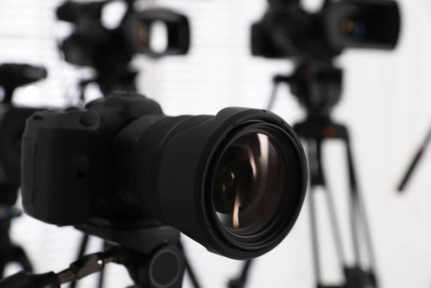 Modern video camera indoors, focus on lens. Professional media equipment for broadcasting event - Zdjęcie, obraz