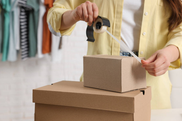 Seller packing cardboard box in office, closeup - Photo, image