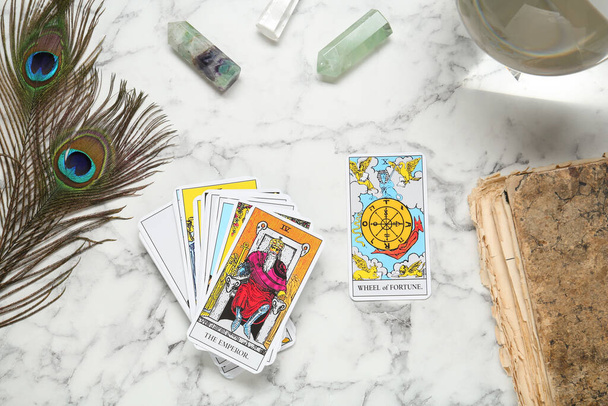 Flat lay composition with Emperor, Wheel of Fortune and other tarot cards on white marble table - Photo, Image