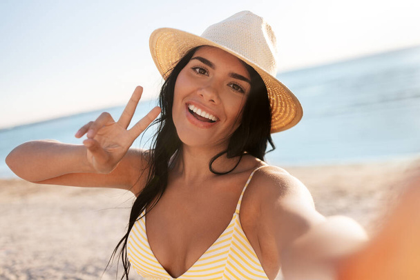 smiling woman in bikini taking selfie on beach - Foto, imagen