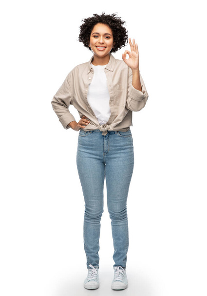 happy woman in shirt and jeans showing ok gesture - Photo, Image