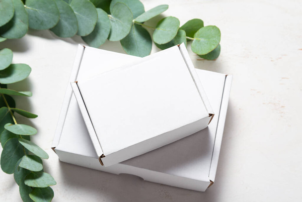 White cardboard carton box decorated with Eucalyptus green branc - Fotoğraf, Görsel