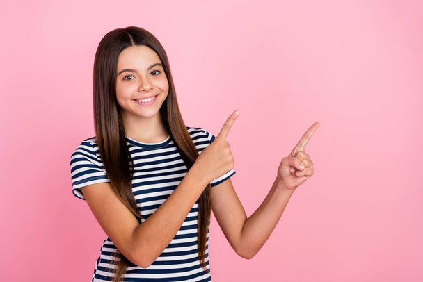 Photo of sweet shiny girl wear striped outfit pointing fingers empty space isolated pink color background - Fotografie, Obrázek