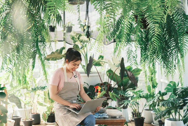Junge Pflanzenverkäuferin überprüft Kundenauftrag von Website - Foto, Bild