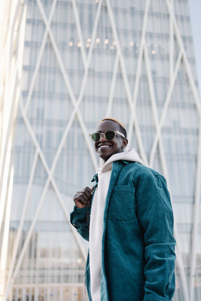 Πορτρέτο του σύγχρονου άνδρα με αυτοπεποίθηση μαύρο Αφρικής με γυαλιά ηλίου και κουκούλα στην πόλη - Φωτογραφία, εικόνα