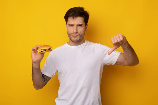 Unhappy Man Holding Burger Showing Thumbs Down - Photo, Image