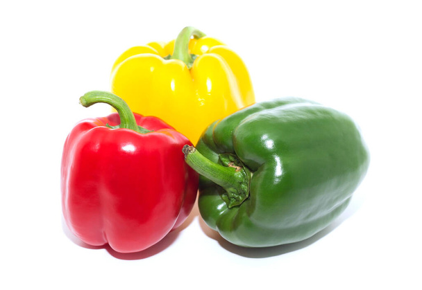 Drie aparte rode, groene, gele paprika, witte achtergrond. - Foto, afbeelding