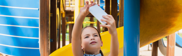 girl taking selfie on mobile phone in amusement park, banner - Foto, Imagen