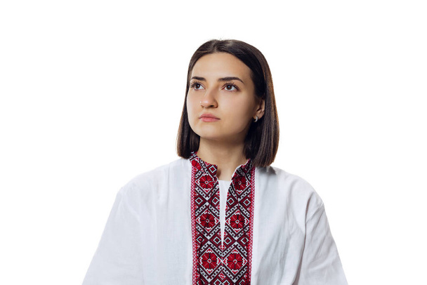 Portrait of emotive woman in ukrainian traditional cloth - embroidery shirt, vyshyvanka isolated over white studio background. - Photo, image