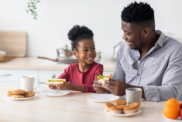 Щасливий африканський батько з донькою насолоджуються здоровим сніданком - Фото, зображення