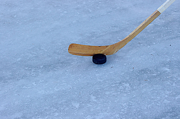 palo de hockey de madera con disco en hielo blanco con espacio de copia - Foto, Imagen
