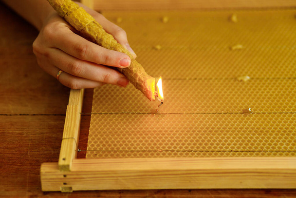 Λιώσιμο κεριών. Γυναίκα εργάζονται σε ένα νέο πλαίσιο, Στερέωση του σύρματος στην πλάκα κερί με κερί - Φωτογραφία, εικόνα