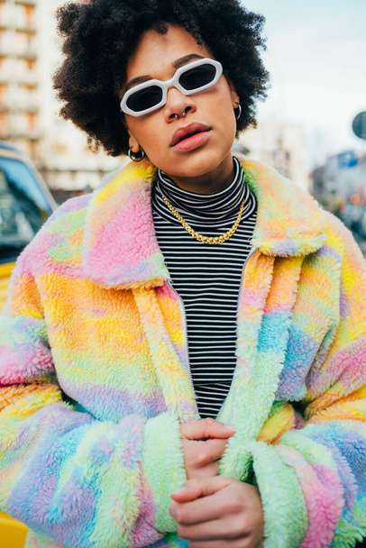 Porträt junge gemischte Rasse lockiges Haar Frau posiert im Freien modisch mit Sonnenbrille zuversichtlich - Foto, Bild