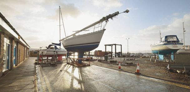Zeilboten staan op het land in een jachtclub. Rhu marina, Firth of Clyde, Schotland, Verenigd Koninkrijk - Foto, afbeelding