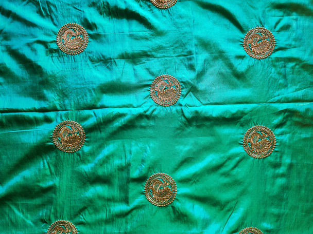 Фотографія прекрасного морського зеленого розплідника шовкові сарі з золотими кольорами круглої форми. Знімок знятий під природним світлом у Бангалор (Карнатака, Індія).. - Фото, зображення