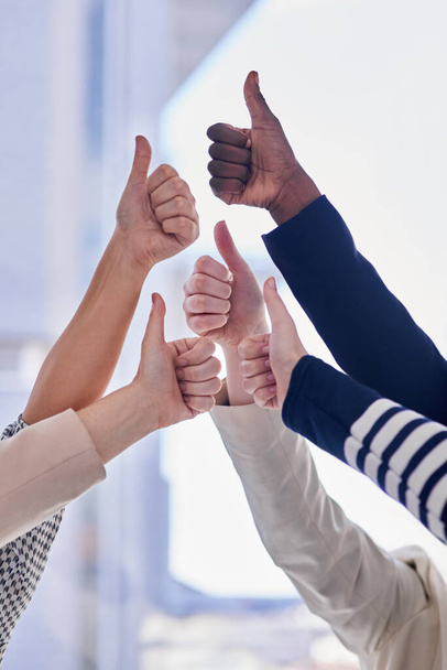 Positive about business. Cropped shot of a group of businesspeople giving thumbs up in an office. - Foto, Imagem