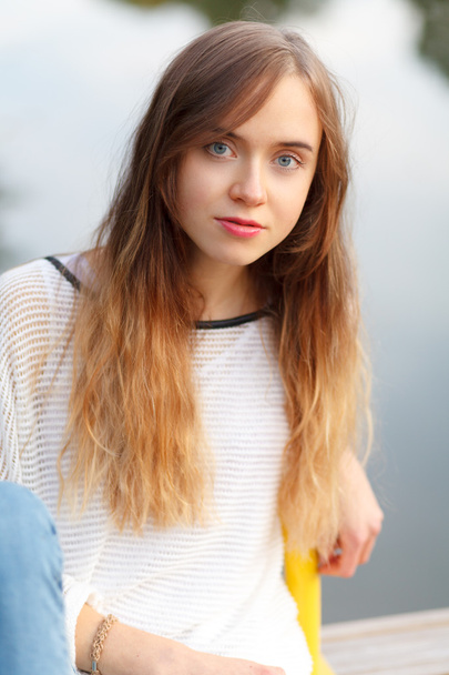 Young beautiful girl sitting on a pier - Foto, immagini