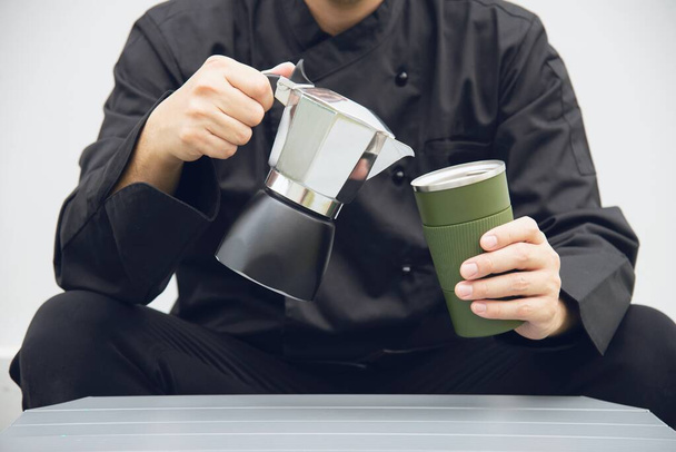 Asian barista is making hot coffee using moka pot - Fotó, kép