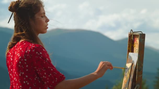 Pittore meditativo disegno quadro nelle montagne estive. Pittura primo piano artista - Filmati, video