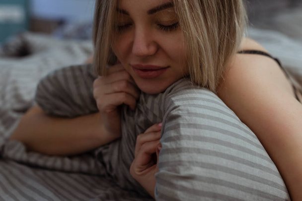 O orgasmo feminino. Uma menina sexy solitária em sua roupa interior jaz na cama em seu prazer do rosto. Masturbação e sexo oral - Foto, Imagem