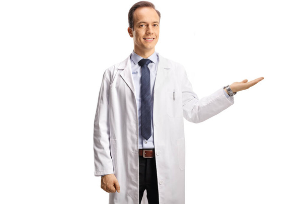 Férfi orvos mutatja a kezét, és néz kamera elszigetelt fehér háttér - Fotó, kép
