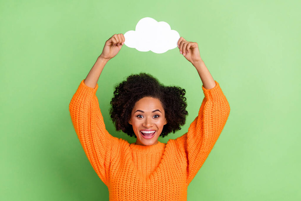 Portrait of attractive cheerful girl holding in hand cloud copy space having fun isolated over green pastel color background - Фото, изображение