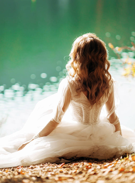 La joven novia sentada cerca del lago - Foto, Imagen