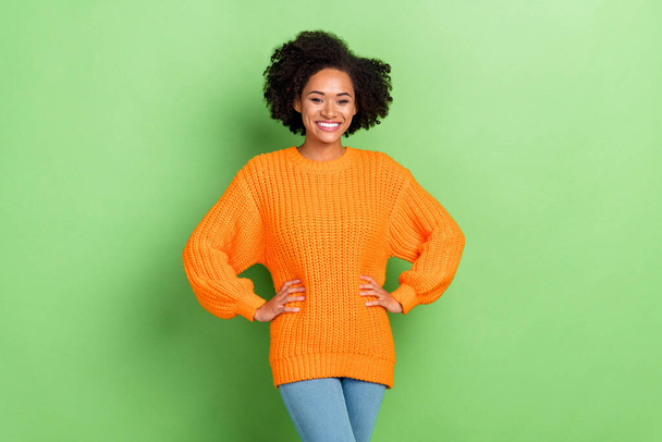 Photo of sweet millennial curly hairdo lady wear orange jumper jeans isolated on green color background - Valokuva, kuva