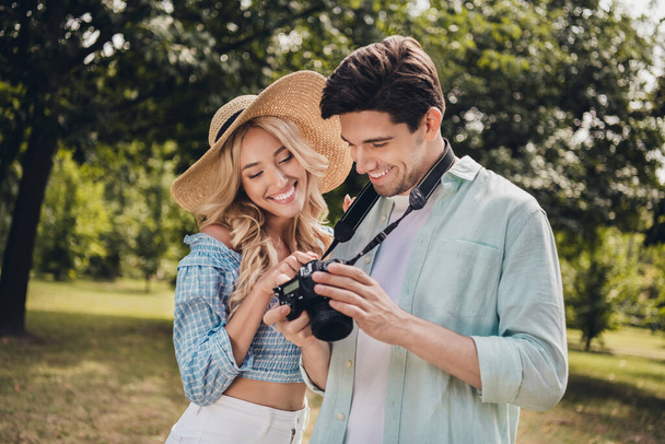 Portrait of two attractive cheerful couple choosing captures snap shot of model pastime portfolio outdoors - Foto, imagen