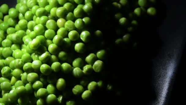 黒盆の上で新鮮な緑のエンドウ豆の山 - 映像、動画
