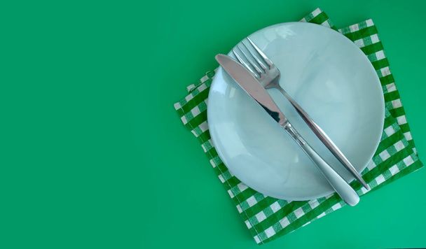 пустая тарелка, вилка, нож на цветном фоне - Фото, изображение