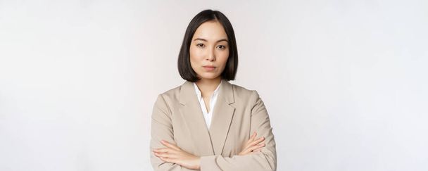 Empreendedor feminino confiante, mulher de negócios asiática em pé em pose de poder, pessoa profissional de negócios, braços cruzados no peito, de pé sobre fundo branco - Foto, Imagem