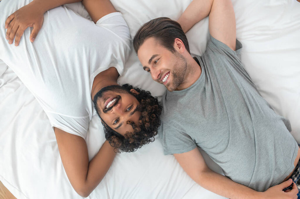 Joyful gay couple resting in their bedroom - Fotoğraf, Görsel