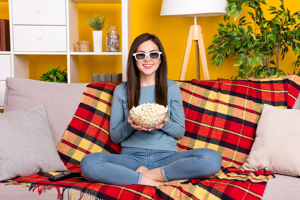 Full size portrait of cheerful lady sit couch hold popcorn plate isolated on yellow color background - Foto, Bild