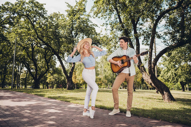 Full length body size view of two attractive glad cheerful couple playing guitar dancing having fun rest pastime on fresh air outdoors - Fotó, kép