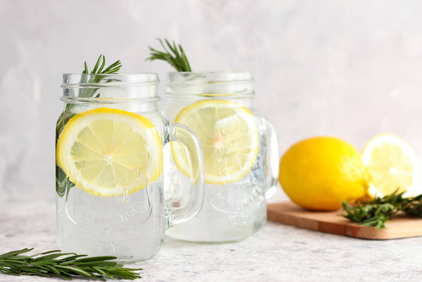 Homemade lemonade with ice, lemon and rosemary. Refreshing summer drinks. Detox concept. Close-up, selective focus - 写真・画像
