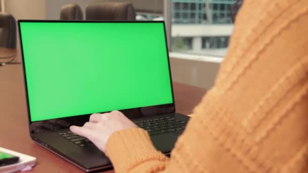 Mujer joven escribiendo en el ordenador portátil, toma lupa para examinar algo en la pantalla verde, acercarlo. Tecla de croma, maqueta - Metraje, vídeo