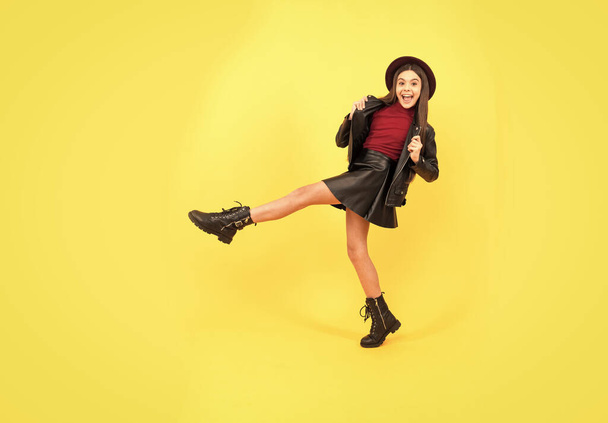 happy girl in leather wear. dancing stylish teen child making wide step. - Photo, Image