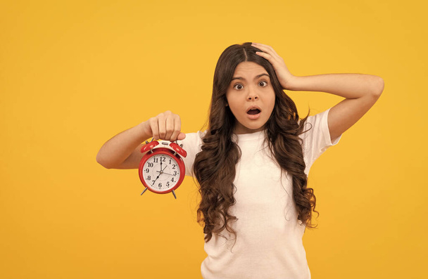 беспокойная девушка подросток держать ретро будильник показывает время, позднее пробуждение - Фото, изображение