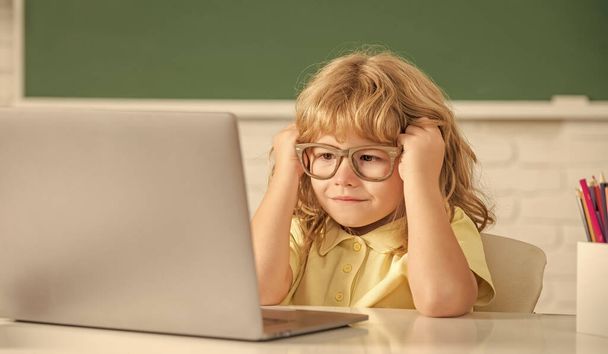 知識の日だ。オンライン教育の概念です。ノートパソコンを持ったメガネのオタクの子供。9月1日 - 写真・画像